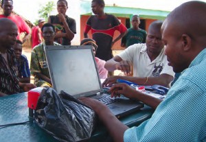 An Opportunity Mozambique loan officer uses Enterprise Open Sky technology to set up accounts for farmers and rural families residing in the bush. Community members.