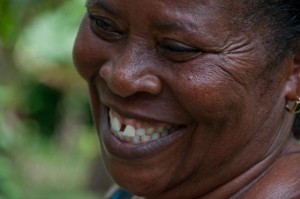 Opportunity Ghana client Beatrice Boaten smiles while standing at her farm. (Photo: Sara Joe Wolansky)