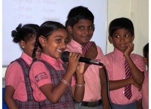 Ramya, a scholarship recipient, takes the mike to introduce herself to Insight Trip travelers when they visit her school.