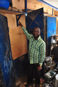 James Aby Kwame Prah, a MicroEnsure Ghana client, shows the water level in his Accra shop after last year’s floods. MicroEnsure’s insurance is helping him rebuild his shop.