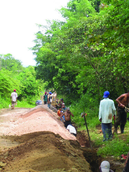 Members of the La Laguna community work to build the trench.