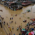 Residents wade along a flooded road in Marikina City, east of Manila. (Aaron Favila/AP)