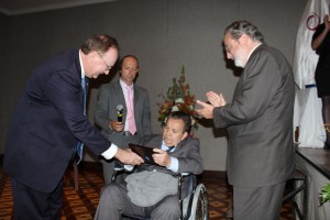 David Simms hands a commemorative plaque to Carlos Moreno, with Enrique Ordonez at right.