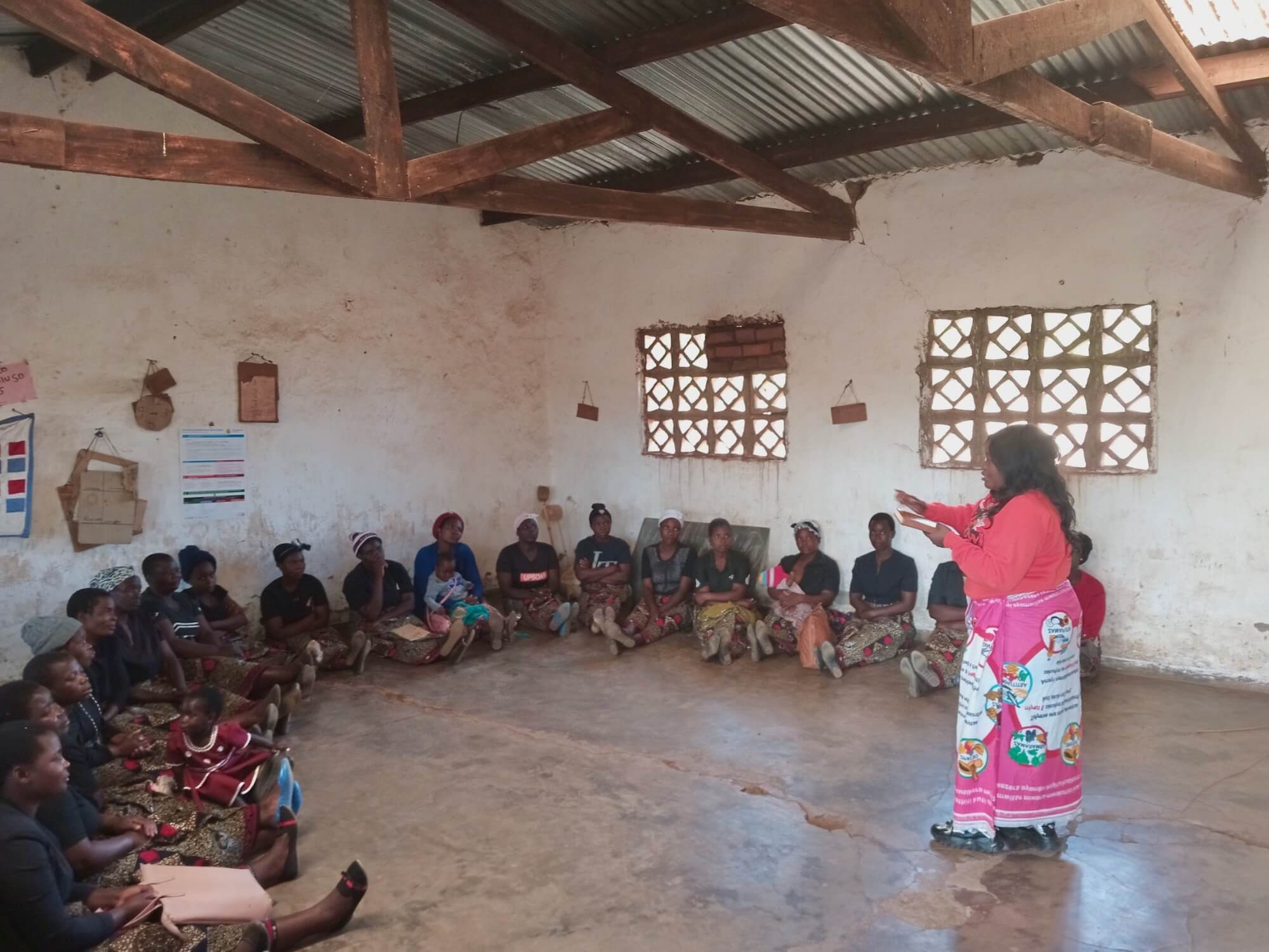 Khumbo Msutu, Opportunity Digital Financial Services Project Officer, provides training to a savings group in Malawi. 