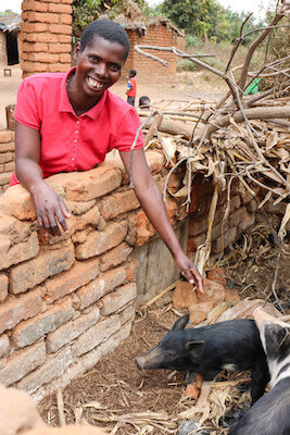 Since working with Opportunity, Bernedette has diversified her income to include goats and pigs, opened a savings account, and has added a metal roof to her home.
