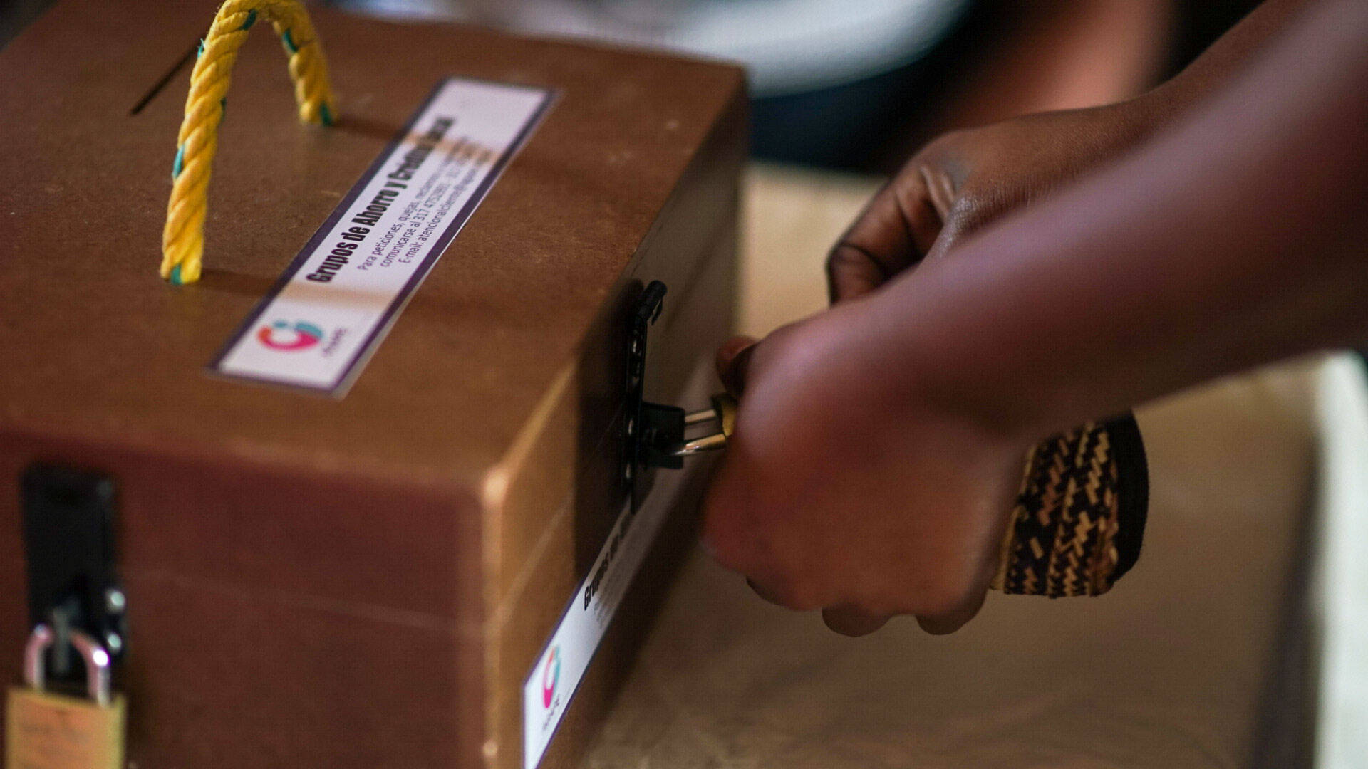 Opening the lockbox at the “Seeds of Blessing” savings group meeting in Colombia.