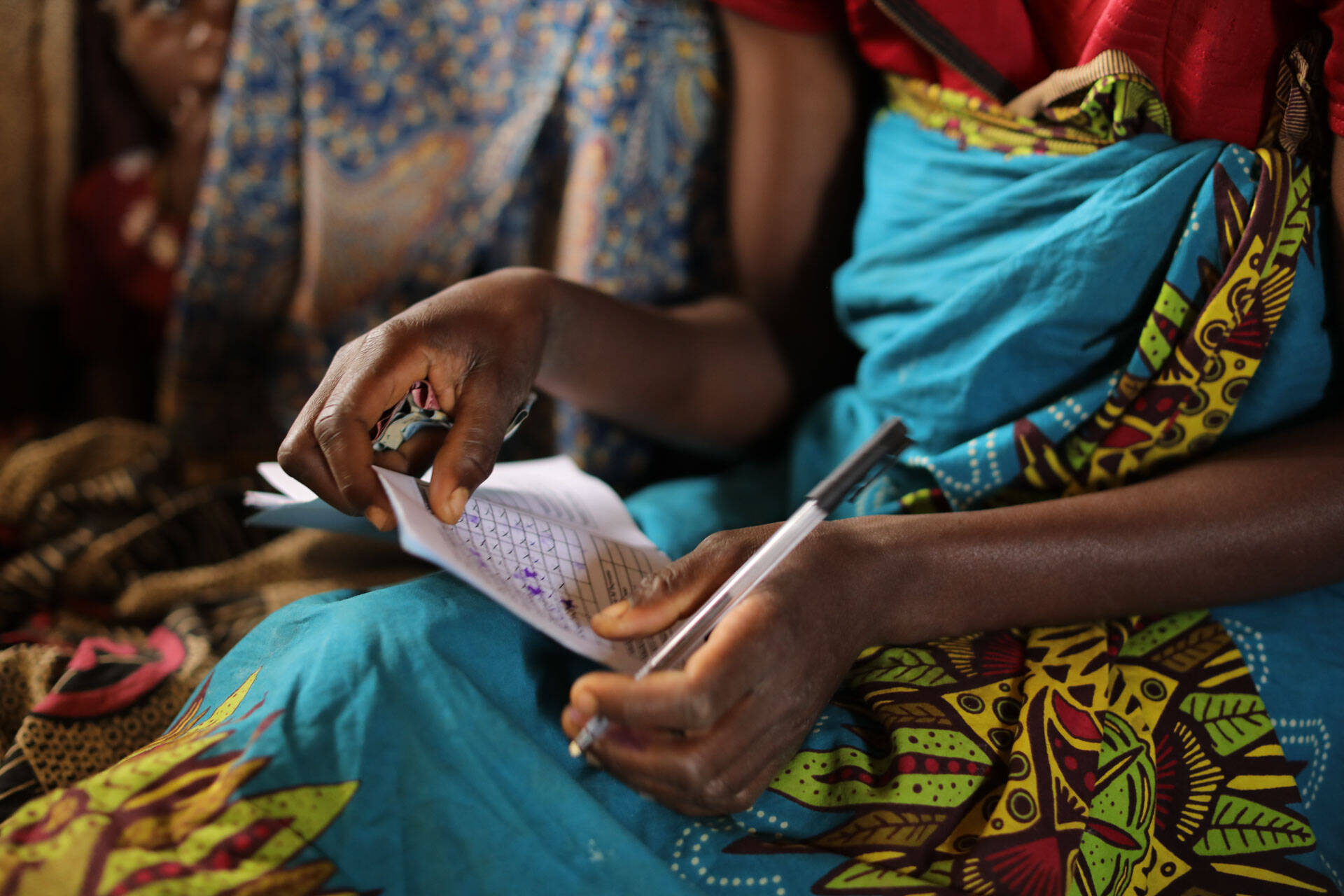 Member shares are recorded by hand at the “Tikondane” savings group meeting in Malawi. 